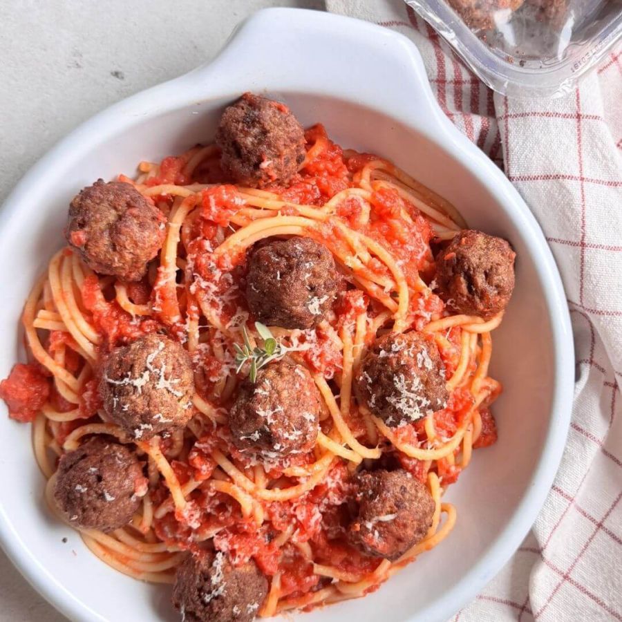 Piatto di spaghetti al pomodoro con polpettine vegetali Vegamo croccanti, serviti con sugo profumato all’origano e basilico, ricetta vegana ispirata a Lilli e il Vagabondo.