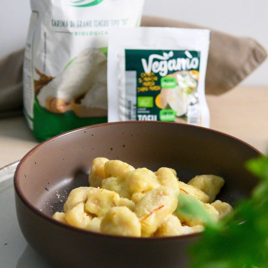 Gnocchetti proteici allo zafferano senza patate preparati con tofu Vegamo e farina bio, serviti con salsa cremosa vegetale.