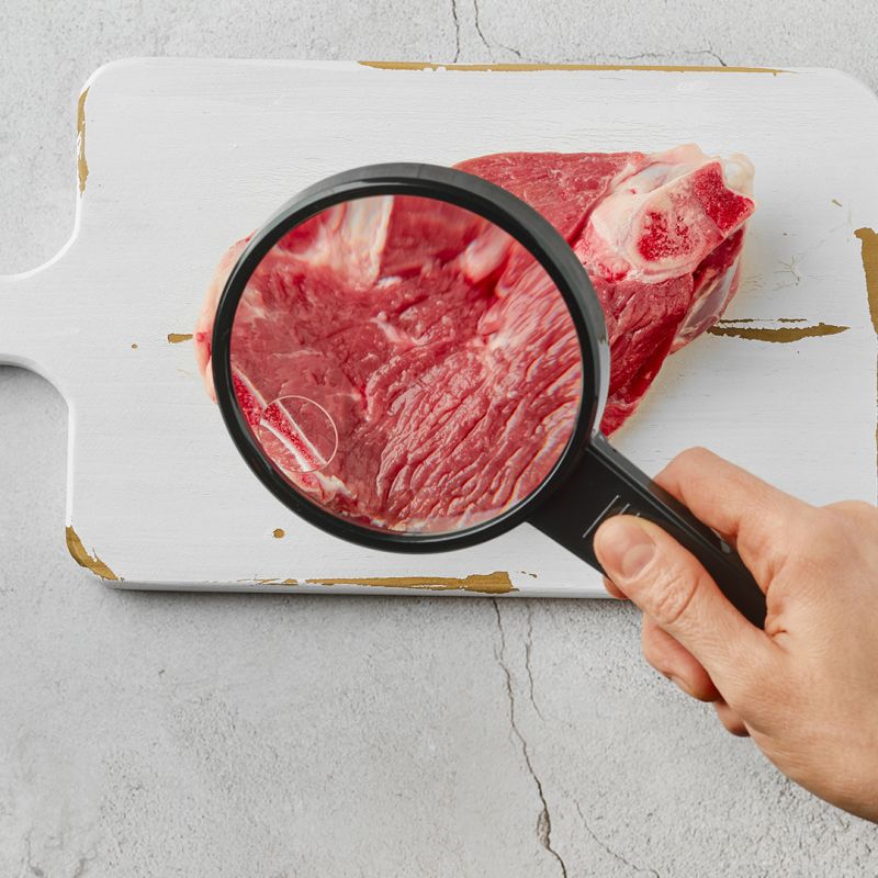 Concetto di carne coltivata. Carne su tagliere, vista dall'alto.