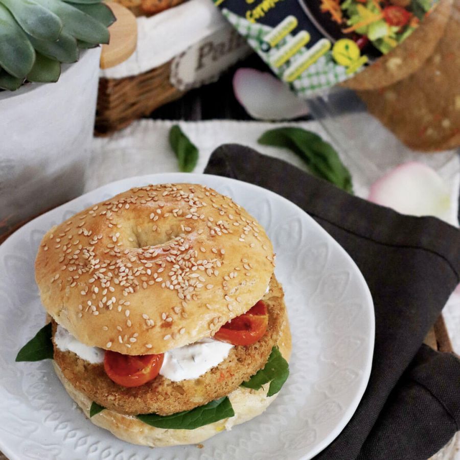 Bagel con burger vegetariani al formaggio, pomodorini arrosto e spinacini