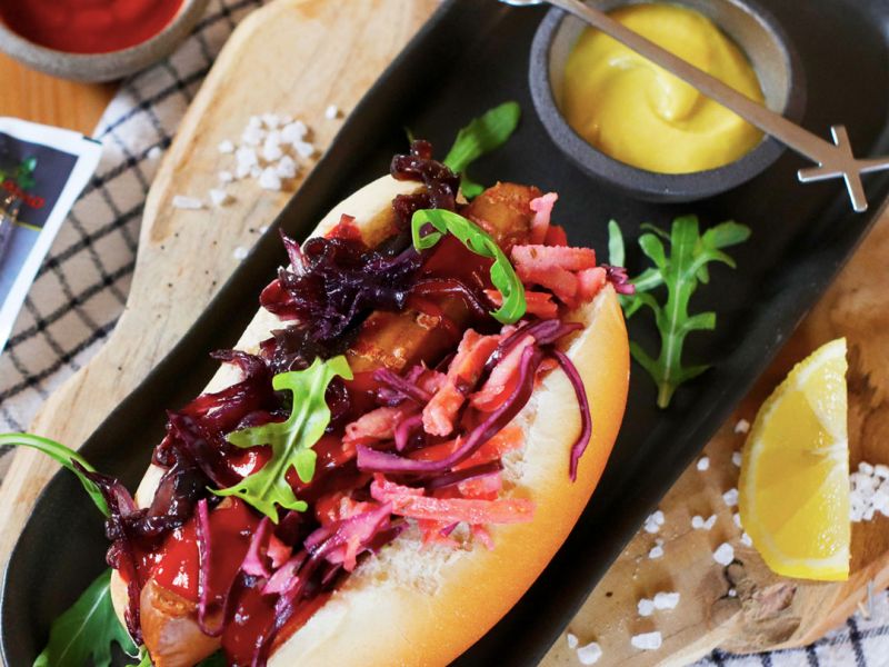 Vegan hot dog con insalata coleslaw e cipolla caramellata