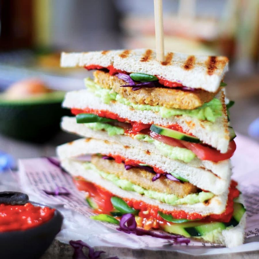 Vegan club sandwich con cotoletta, avocado e salsa ajvar