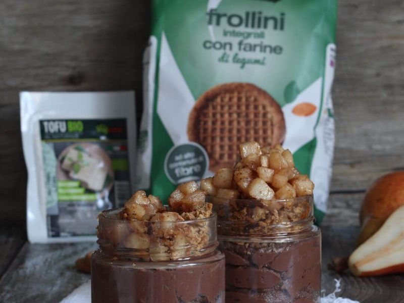 Coppetta dessert con mousse proteica al cioccolato (tofu Vegamo), crumble di frollini ai legumi e cubetti di pera caramellata, servita in vetro