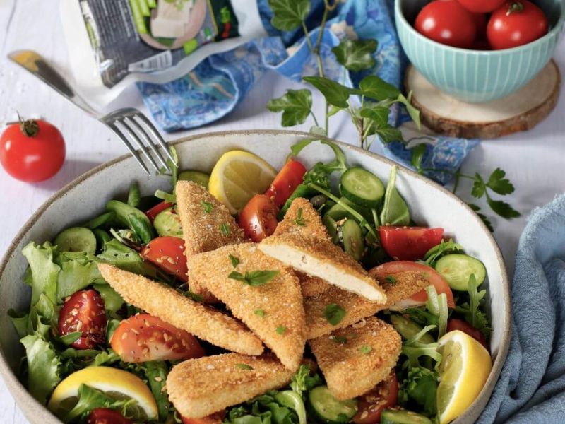 Triangoli di tofu panati croccanti serviti con verdure di stagione e fettine di limone