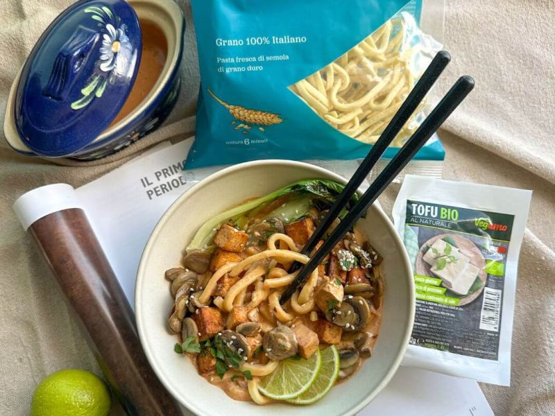 Ciotola di ramen all’italiana con tofu croccante, scialatielli, funghi trifolati, pak-choi, brodo al latte di cocco, fettine di lime e sesamo, servito con prezzemolo fresco