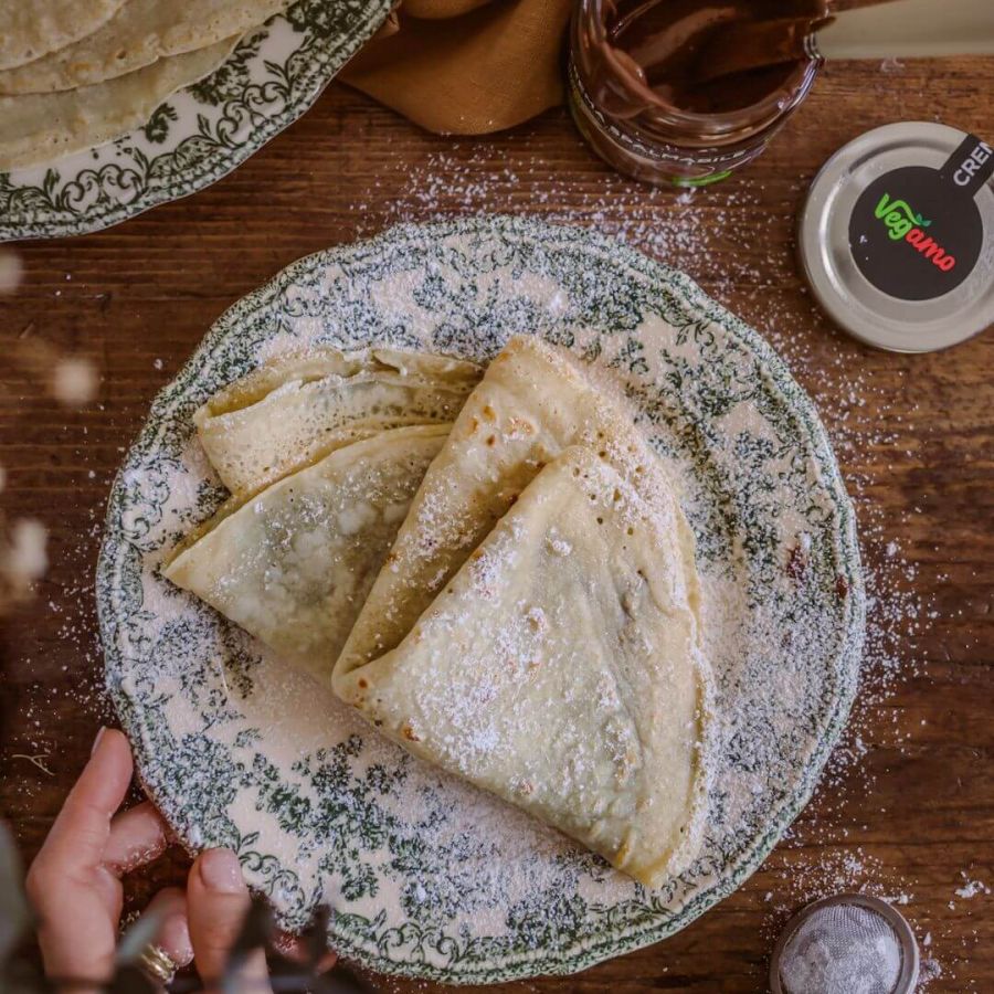 Crêpes vegane 100% vegetali, farcite con crema spalmabile al cacao e nocciole Vegamo. Ricetta facile per una colazione o merenda golosa, senza zuccheri aggiunti.