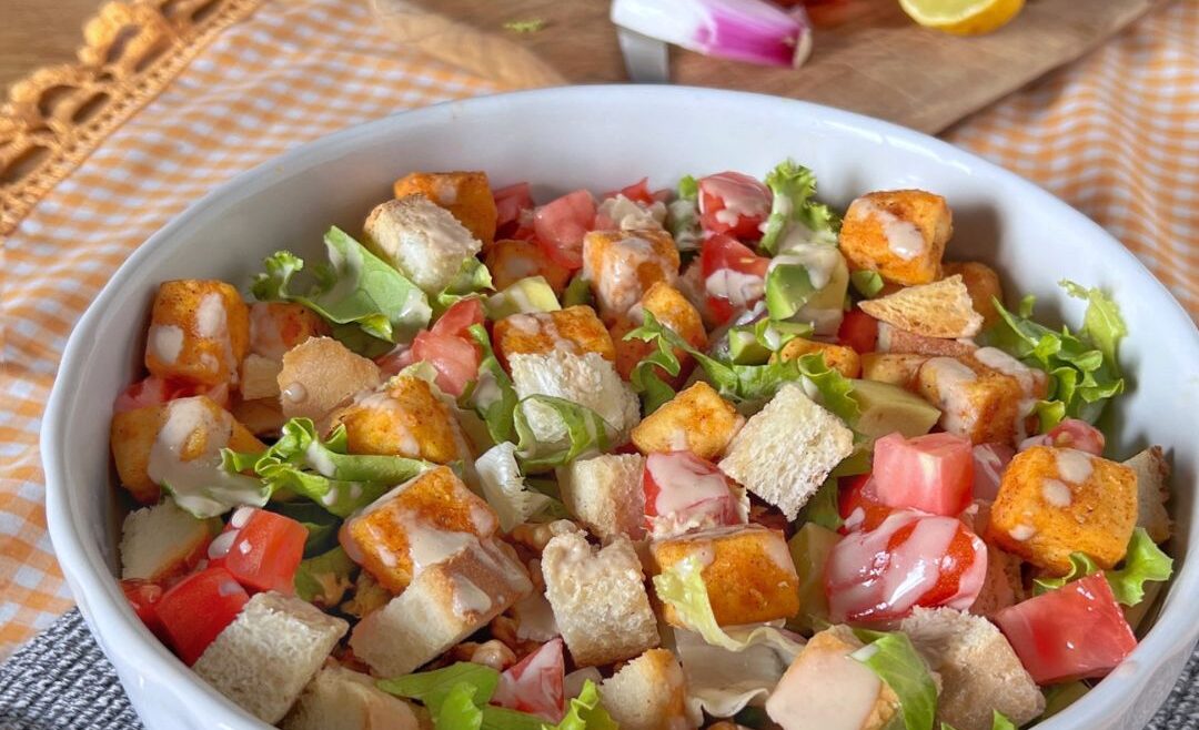 tofu salad colorata e vegana, bowl di insalata con tofu, avocado, pomodorini e crostini di pane